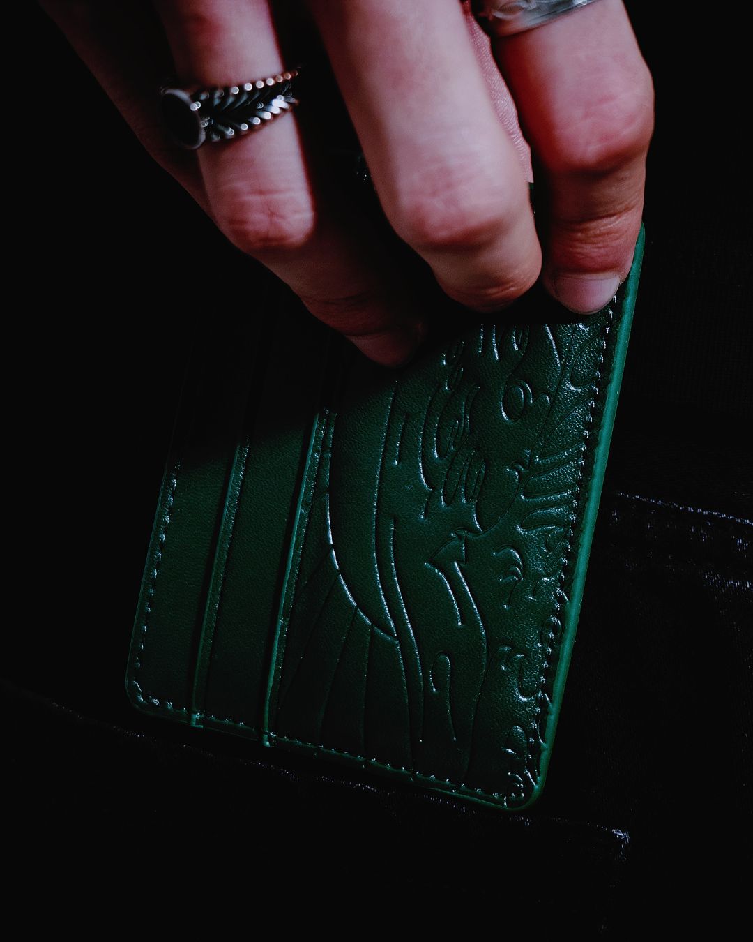 Cartera Kanagawa verde sostenida en mano